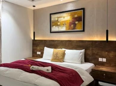 Bedroom with pendant lights, framed art and red throw